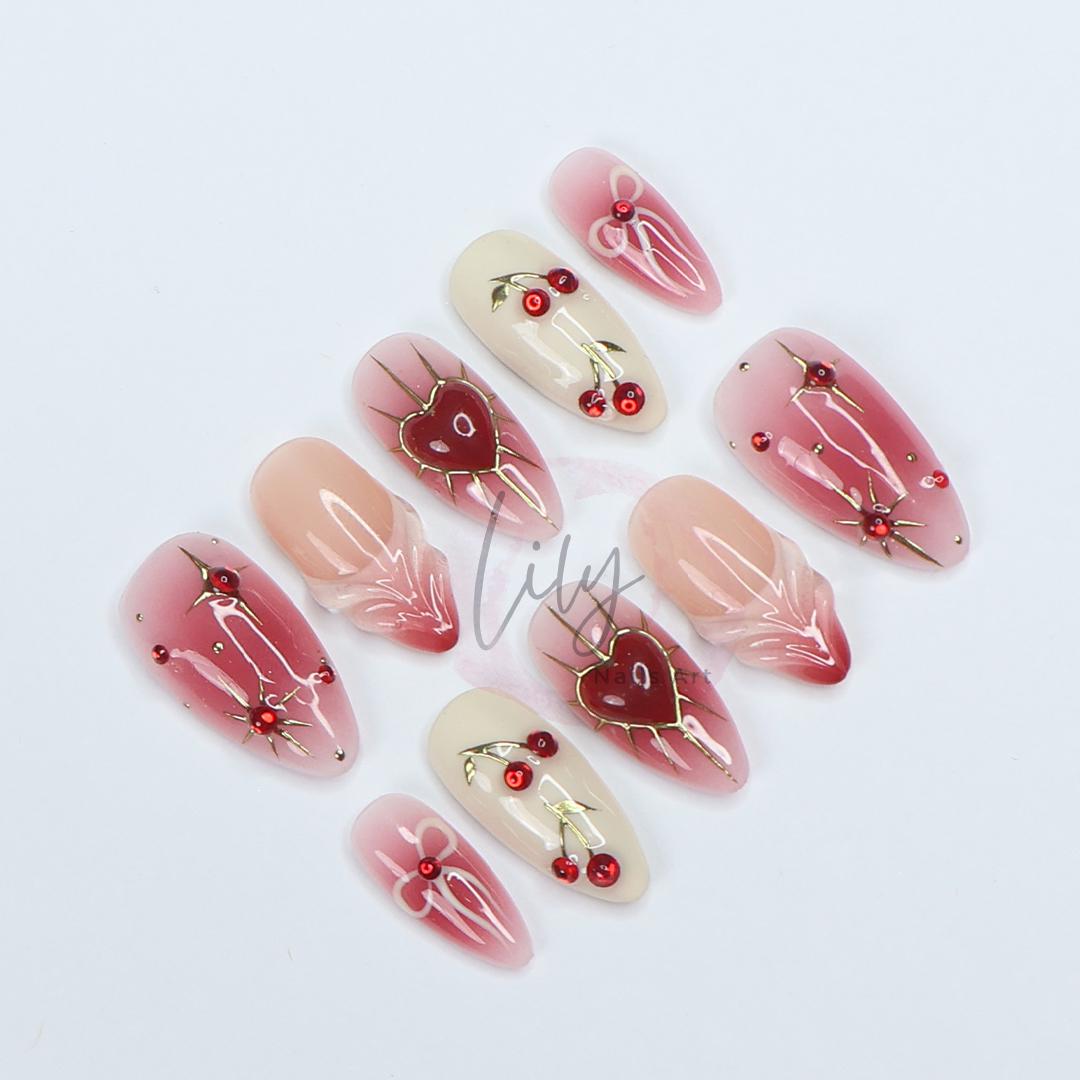 Elevate your nail with Red Aura Press-On Nails, featuring 3D gel hearts and cherries in medium almond, perfect for gifting or everyday glam