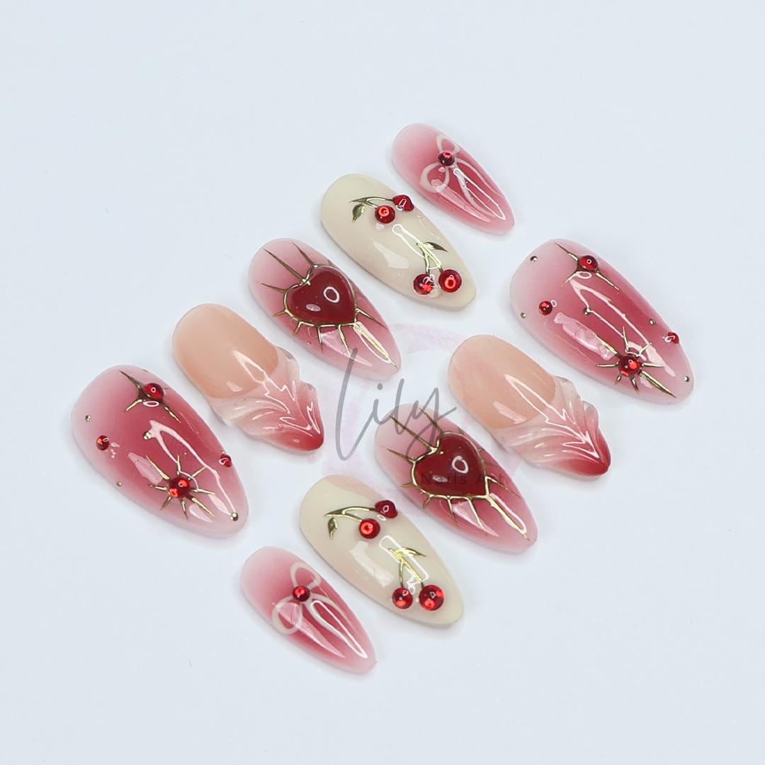 Elevate your nail with Red Aura Press-On Nails, featuring 3D gel hearts and cherries in medium almond, perfect for gifting or everyday glam