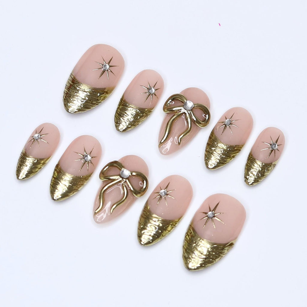 Gold Press On Nails | Nude Base with Gold Bow & Star Design | Medium Almond Fake Nails | Handmade Nail Art for Everyday Wear