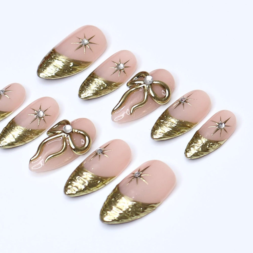 Gold Press On Nails | Nude Base with Gold Bow & Star Design | Medium Almond Fake Nails | Handmade Nail Art for Everyday Wear